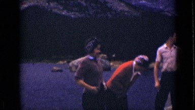 1939: group of people standing on shoreline with mountainous background COLORADO