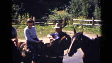 1939: people are getting ready for horse riding and guy is fixing horse snaffle