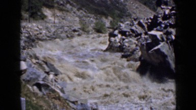 1939: turbulent flow of muddy water through valley with large rocks UTAH