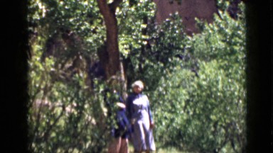 1939: two women outside looking at something and talking to each other. UTAH