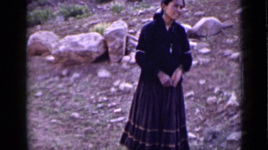 1939: woman in dark sweater and dress standing along hillside UTAH