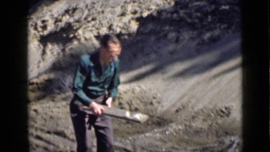 1939: Man Trying to Hit Animal in Forest with Handmade Stick, Utah