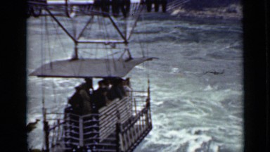 1940: cable car with bunch of people in it are crossing river CANADA