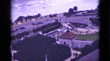 1940: the car in road with trees, lawn, water, buildings CANADA