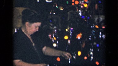 1942: older woman at trimming christmas tree with silver icicles SEBRING OHIO
