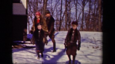 1942: some kids walk down hill in snow with forest behind them SEBRING OHIO
