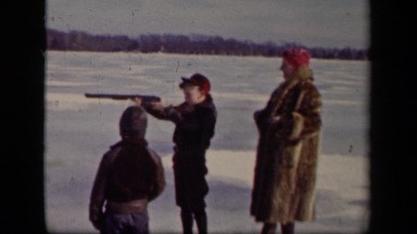1942: small boy takes aim with gun as his mother and brother look on SEBRING