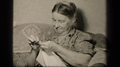 1942: smiling woman sews white cloth SEBRING OHIO