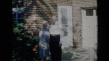 1958: an old couple at backyard of their house looking at their cow MINNESOTA