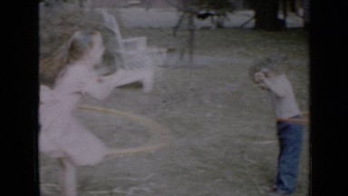 1958: two child girls playing with hula hoop going round and round around
