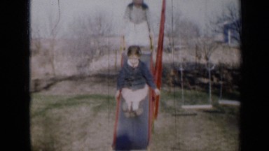 1958: Two Children Going Down Slide, One After Another, Minnesota