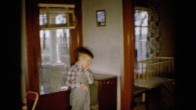 1958: two adults caring their family kids sitting on sofa in their home