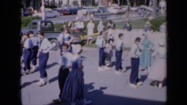 1959: people are dancing in couples at road side while traffic is moving in