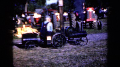 1959: one old man drive black tractor on grassland for expo IOWA