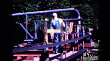 1959: man working with wood cutting machine kept near to trees IOWA