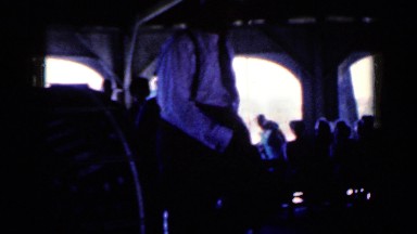 1959: people gathered under what appears to be tent watching well dressed man