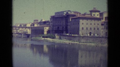 1962: Apartments on Shore of Lake with Calm Water on Sunny Day Florence Italy