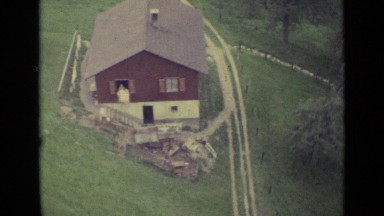 1962: Overhead View of Brown House, Conifers and Valley While Ascending Mountain in Lucerne, Switzerland
