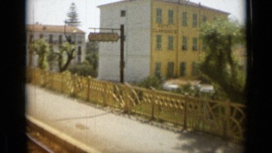 1962: the railway track with street sign, road, trees, car MONACO