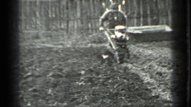 1975: the old man is tilling land with old machine RUSSIA
