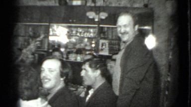 1975: the men are gathered around table with plenty of conversation and drinks