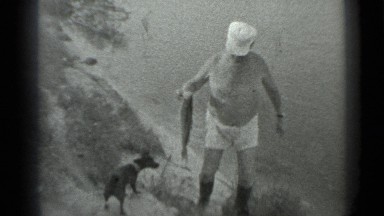 1983: man by lake with dog carrying fish he caught RUSSIA