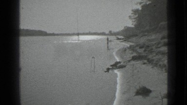1983: large river flowing amid forest and man standing in waters RUSSIA