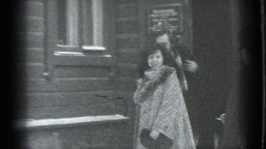 1983: Man Holding Woman's Hand While Exiting Brick Building, Russia