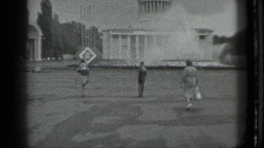 1983: three people walking towards building and all three are holding three
