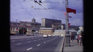 1971: people walking along sidewalk, as cars pass on highway