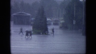 1971: Three Young Men Running Through Courtyard Into Building to Get Out of Rain