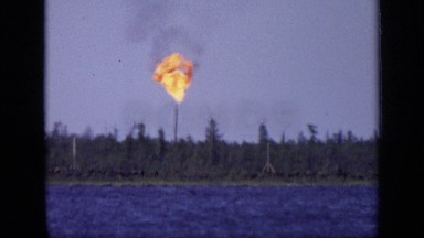 1971: group of men in business attire observe gas flare across body of water