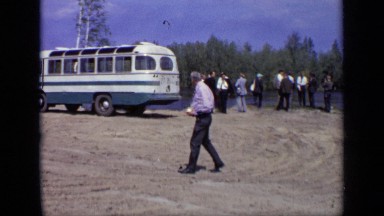 1971: friends hanging out and talking by bus and man just standing and looking
