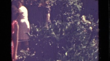 1967: may plays with girl by hugging her dolls during lush outdoor occasion