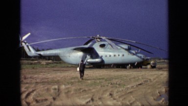 1971: Man with Shoulder Bag Walking Toward Large Blue Helicopter Moscow Russia