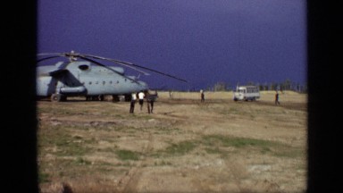 1971: people walking about massive helicopter near bus atop mountain MOSCOW