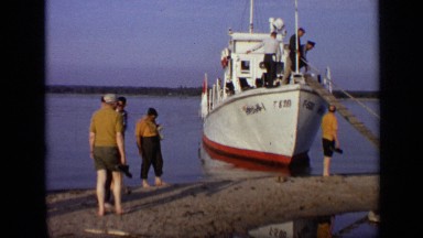 1971: group of people walk up ladder to board boat beached on sandbar MOSCOW