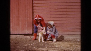 1964: two sisters are cooing their pet in back of house KANSAS