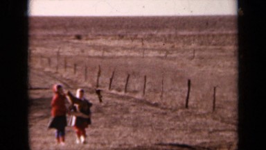 1964: Two Friends Playing on Dry Grass in Kansas