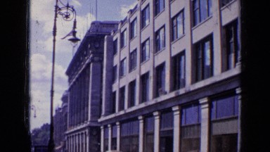 1963: big building with lots of windows and people are roaming down below LONDON