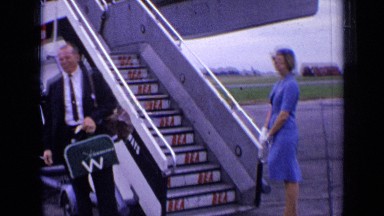 1963: a person waiting to fly in airport, air hosters standing nearby