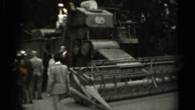 1963: people stand by large farm vehicle with wide mechanism for cutting RUSSIA