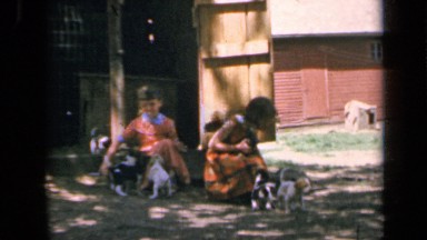 1964: Two Girls Playing With Dog On Kansas Lawn
