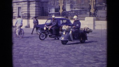 1962: Two Men Riding Bike in Matching White Outfits Through Versailles, France
