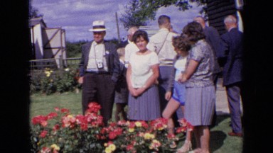 1963: the people were standing in front of flower plants ENGLAND