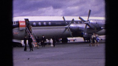 1963: people getting off airplane and walking on tarmac ENGLAND