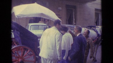 1962: woman in blue dress climbs inside horse drawn carriage as men chat VATICAN