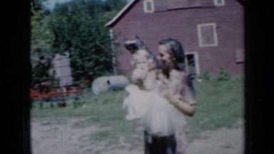 1961: lovely mother is caring here baby in front of house. MISSOURI