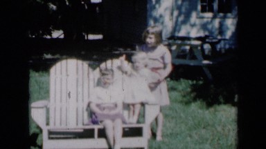 1961: three sisters pose and wave from backyard bench. MISSOURI