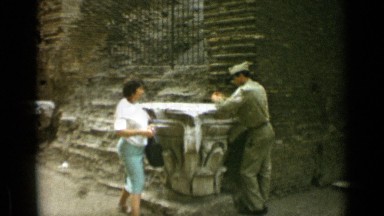 1962: soldier leaning against stonework accepts cigarette offered by woman ROME